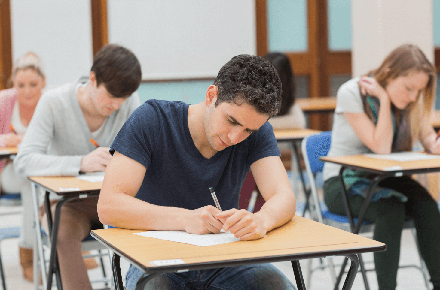 Homme assis qui écrit sur une table