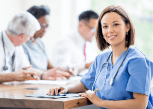 Médecin en premier plan avec une blouse bleue et un stéthoscope