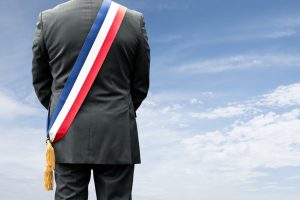 Homme en costume, de dos, avec une écharpe d'élu