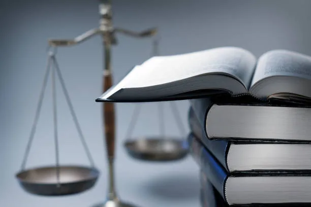 photo d'une balance et de plusieurs livres dont un ouvert