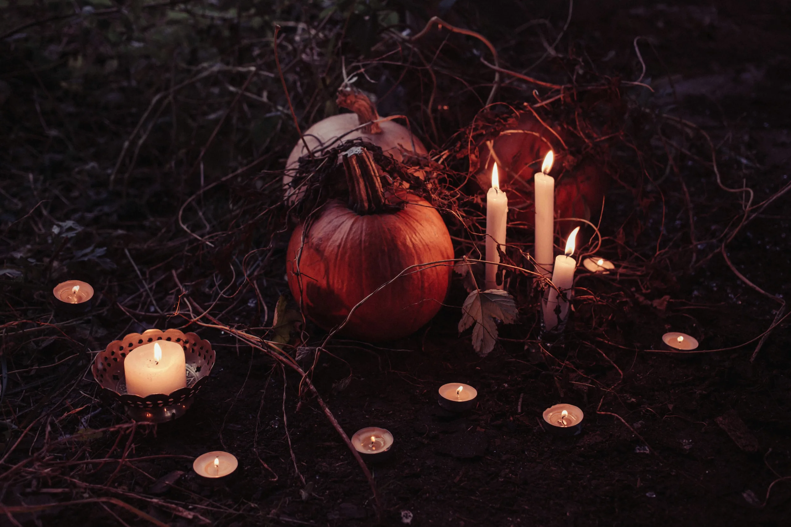 Citrouille dans la nuit, entourée de bougies, rappellant halloween